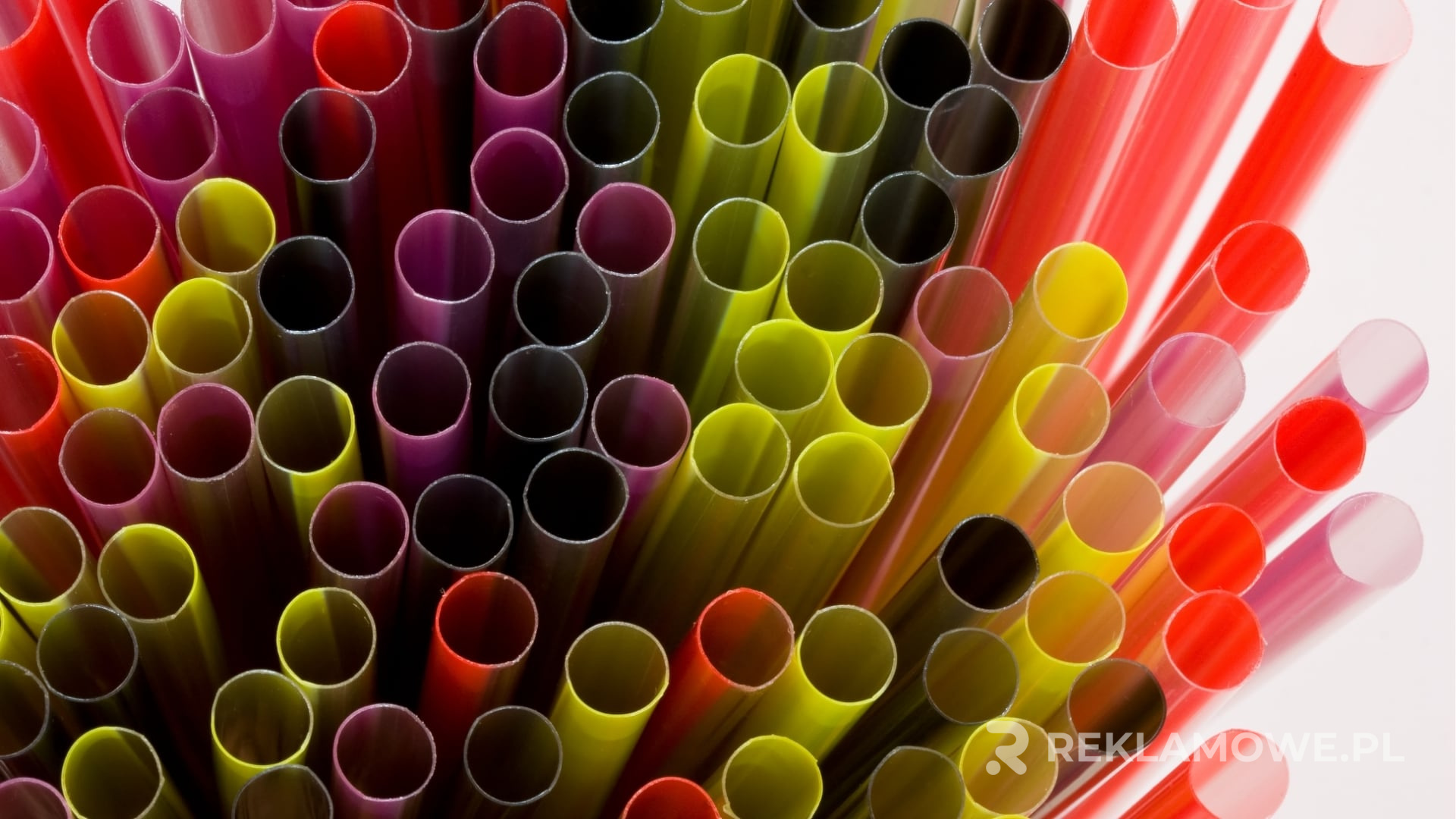 Kolorowe słomki reklamowe na tle firmowego logo